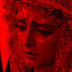 [id: a crying virgin mary statue with a red filter over it]